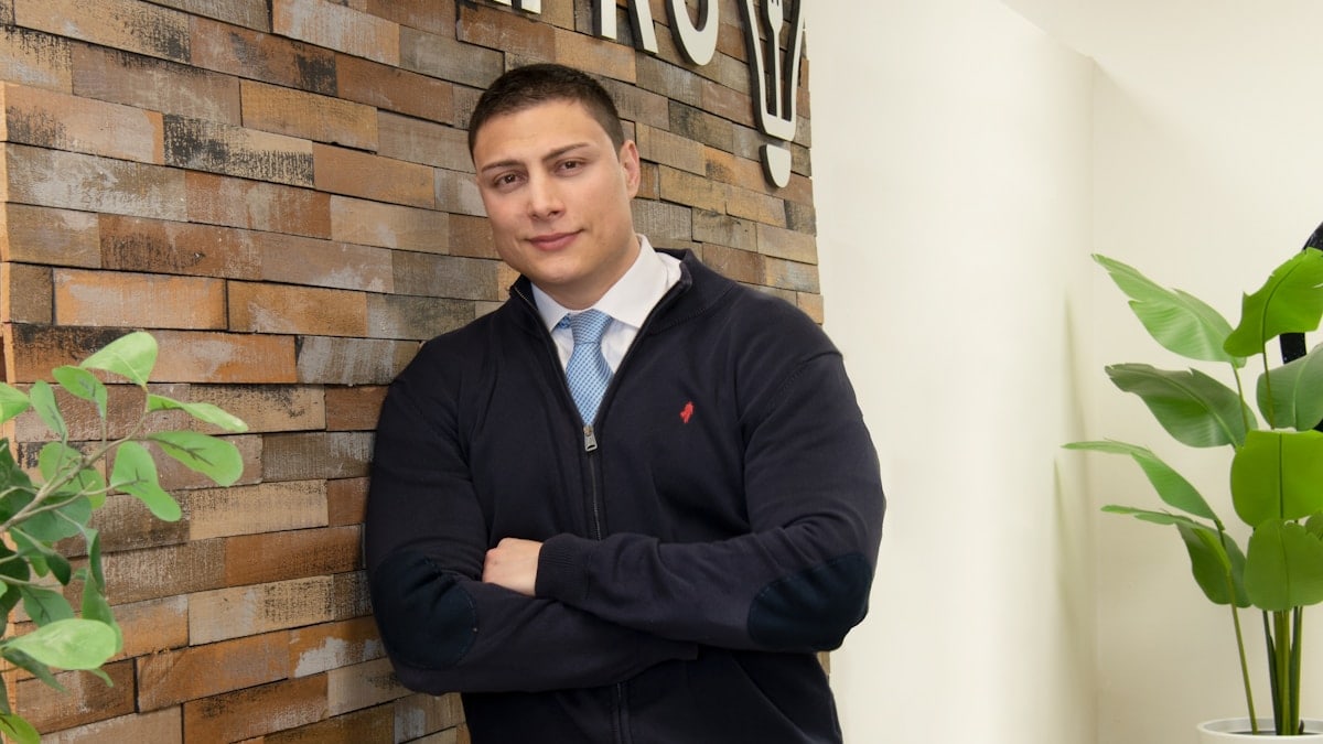A man is standing in front of a sign